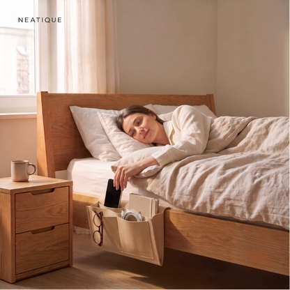 Persoon pakt een telefoon uit de Neatique BedEase bed organizer